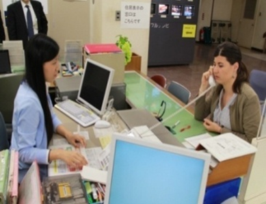 外国人女性が席に座り電話で話をしている写真